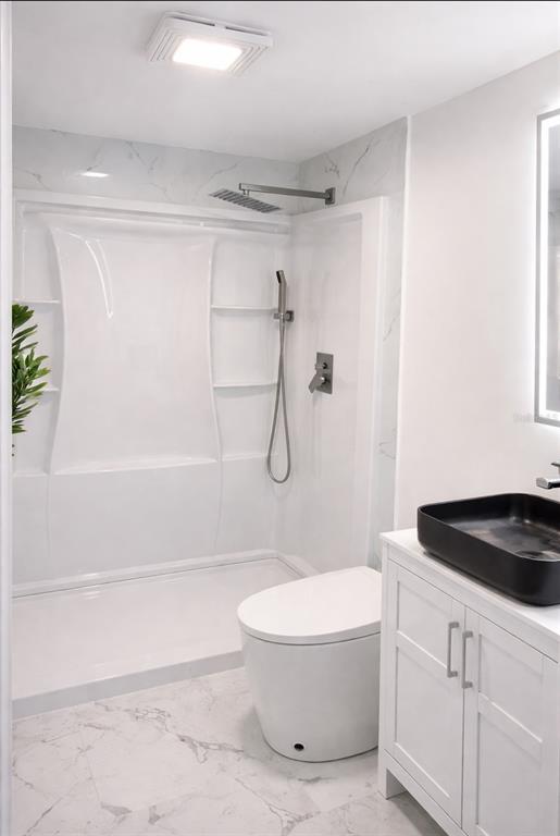 A modern bathroom features a white shower stall, a toilet, and a black vessel sink — 7043 NEW POST DR UNIT 4, NORTH FORT MYERS, FL