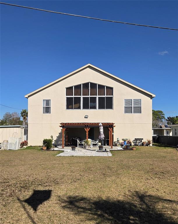 The exterior of a two-story house features a covered patio and a large window array — 6719 MANOR BEACH, NEW PORT RICHEY, FL