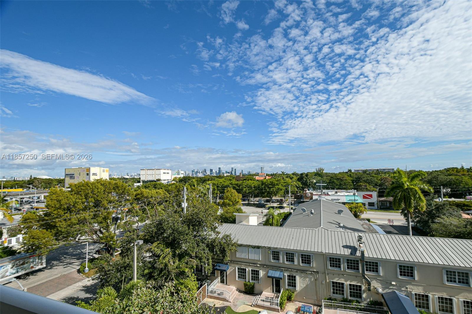 An elevated view shows a suburban landscape with a low-rise building and a distant city skyline — 2740 SW 28th Ter # 603, Miami FL 33133, MIAMI, FL