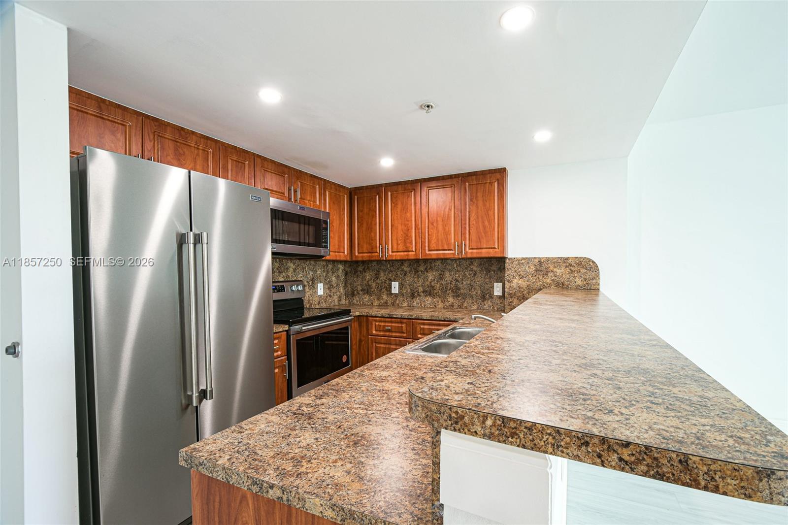 A kitchen features wood cabinets, granite countertops, and stainless steel appliances — 2740 SW 28th Ter # 603, Miami FL 33133, MIAMI, FL