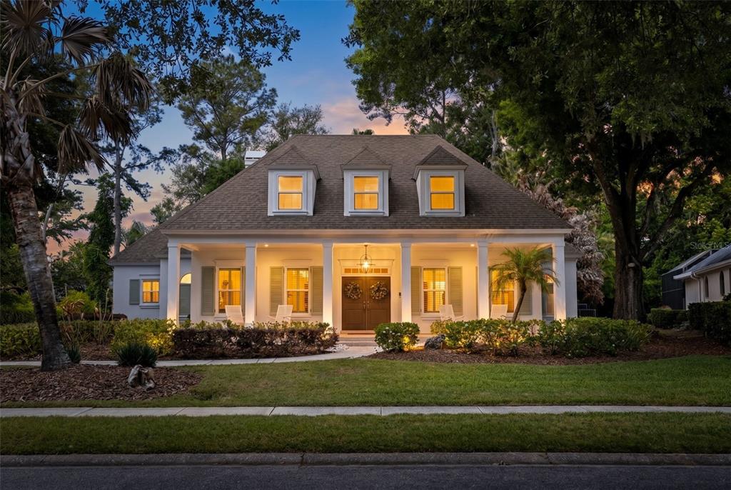 A two-story house with a covered front porch, dormer windows, and a landscaped front yard — 6509 STONINGTON DRIVE S, TAMPA, FL