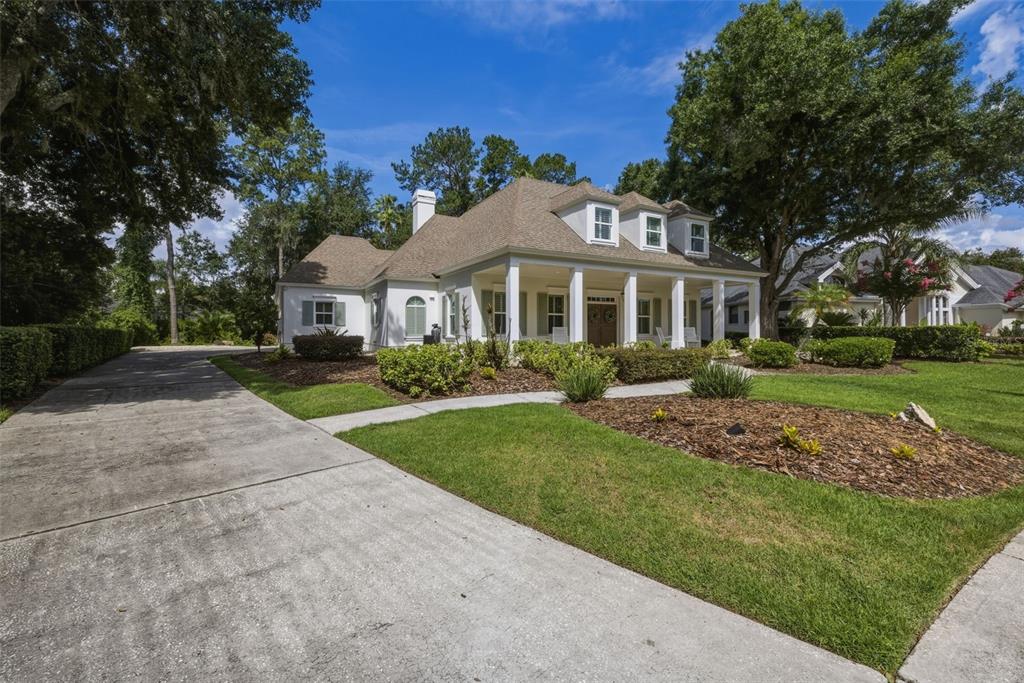 A white single-story house with a covered front porch, dormer windows, and a concrete driveway — 6509 STONINGTON DRIVE S, TAMPA, FL