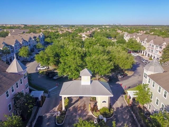 An aerial view shows a gated entrance to a residential apartment complex with surrounding buildings — 6627 QUEENS BOROUGH AVENUE UNIT 108, ORLANDO, FL