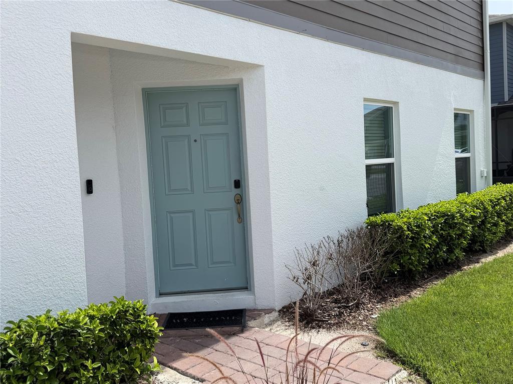 A light blue front door is set into a white stucco exterior wall — 3095 PADDLEBOX POINT, OVIEDO, FL