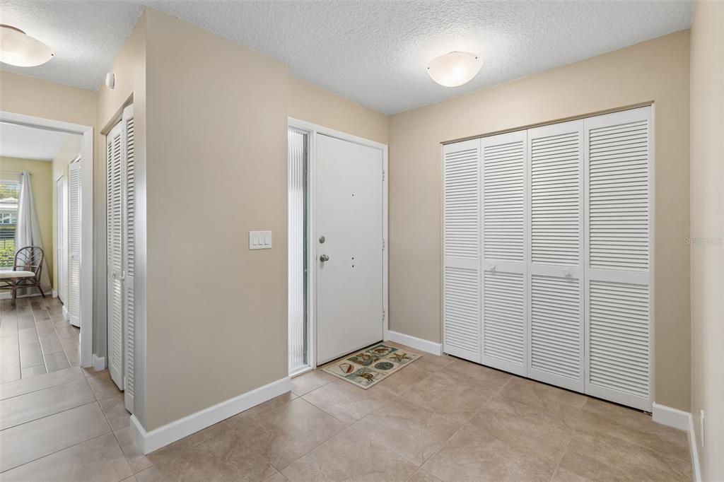 An entryway features tile flooring, a white front door, and white louvered closet doors — 7310 9TH AVE W UNIT 5834, BRADENTON, FL