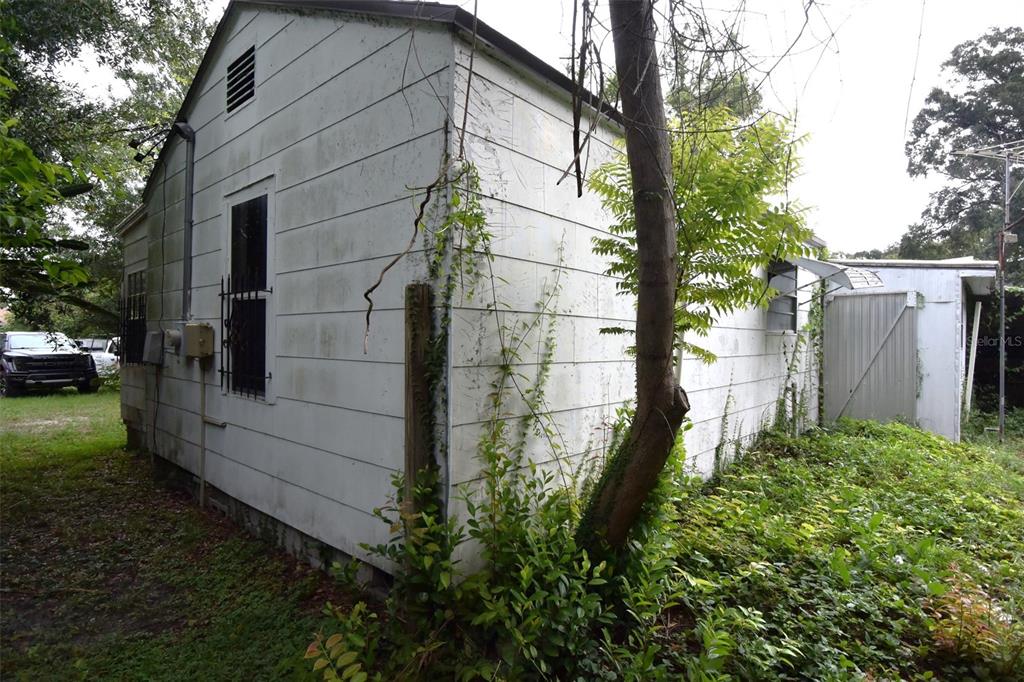 The exterior of a white, weathered building with a metal shed attached to the side — 1422 W HUMPHREY STREET, TAMPA, FL