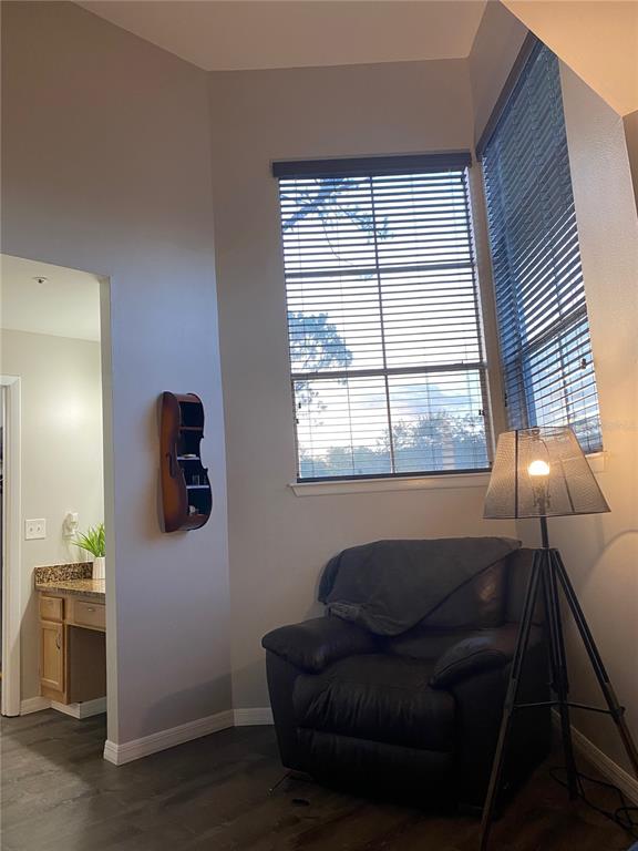 A corner reading nook features a dark leather armchair, a tripod floor lamp, and blinds — 482 N PIN OAK PLACE UNIT 304, LONGWOOD, FL