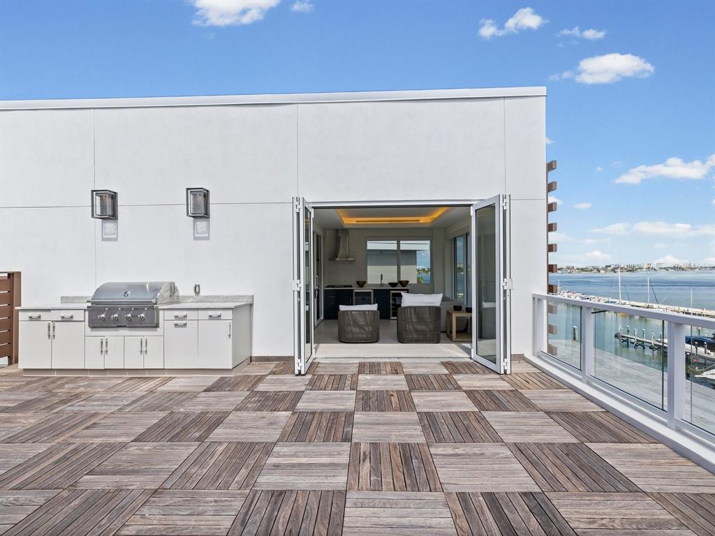 A rooftop deck features wood tile flooring, a built-in grill, and folding glass doors — 868 N OSCEOLA AVENUE, CLEARWATER, FL