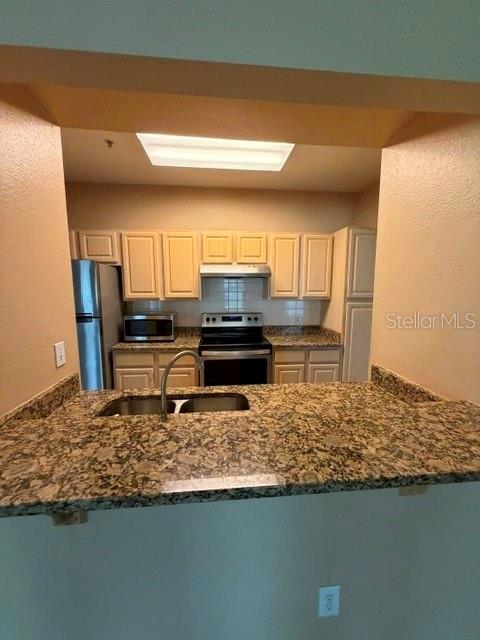 A kitchen with light wood cabinets, granite countertops, and stainless steel appliances — 404 SUMMIT RIDGE PLACE UNIT 212, LONGWOOD, FL