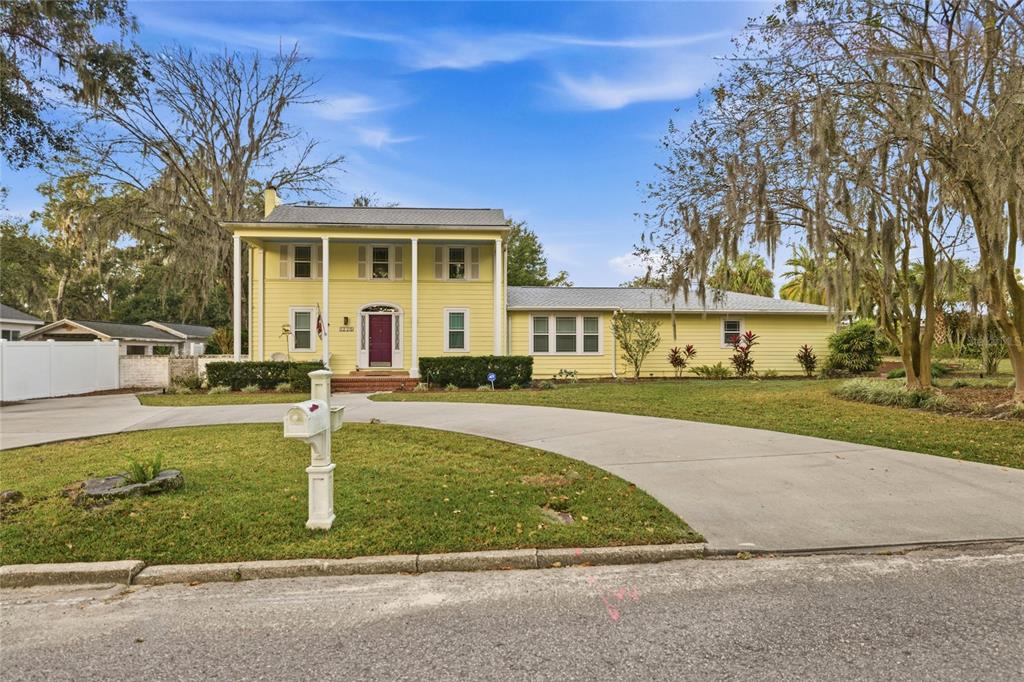 A two-story yellow house with a front porch and a curved driveway at dusk — 1226 SE 9TH AVENUE, OCALA, FL