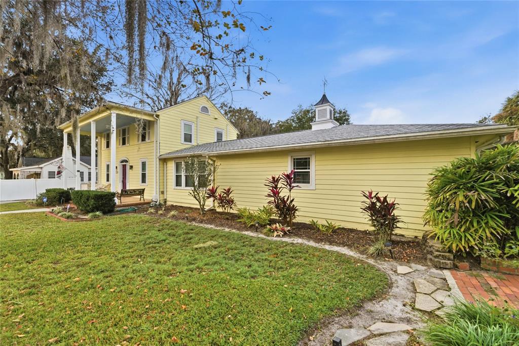 A yellow two-story house with a front porch and an attached single-story wing — 1226 SE 9TH AVENUE, OCALA, FL