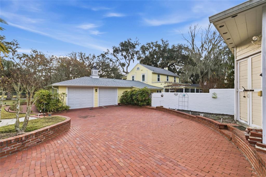 A yellow house with a two-car garage and a red brick driveway — 1226 SE 9TH AVENUE, OCALA, FL
