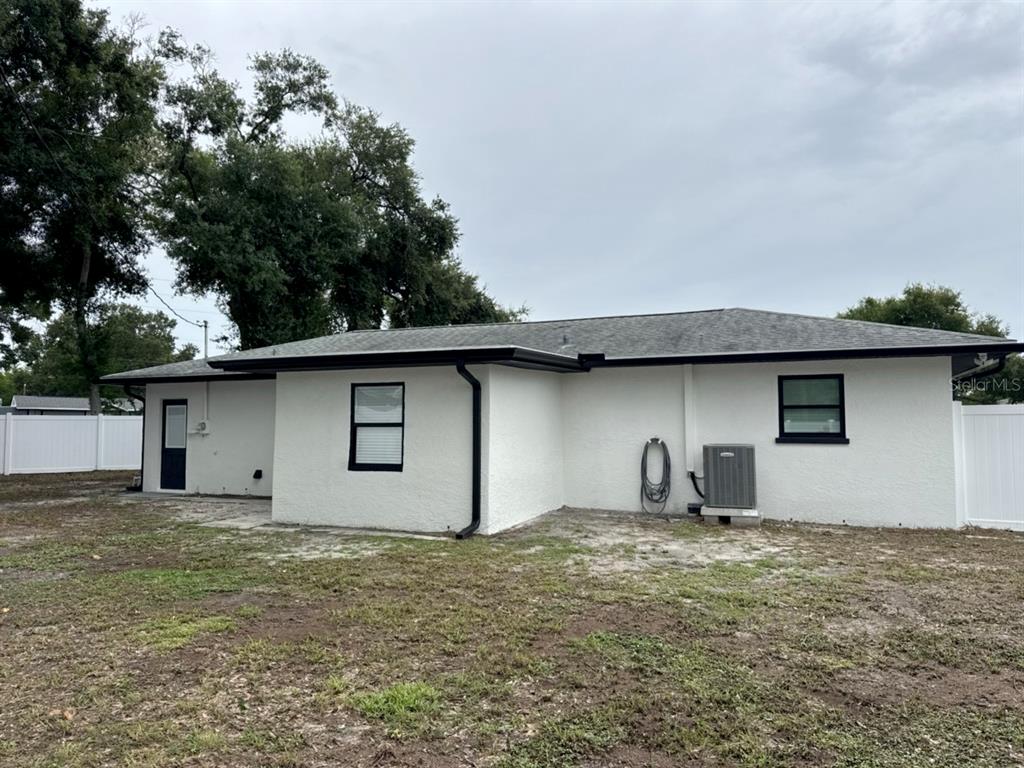 The exterior of a white stucco house features a dark roof and black window frames — 3780 51ST STREET N, ST PETERSBURG, FL