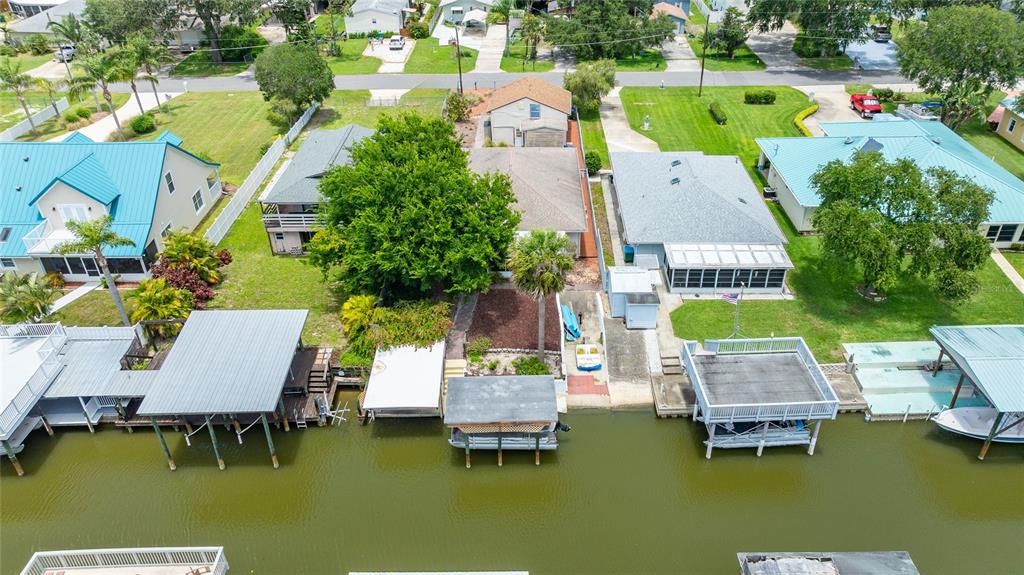 An aerial view shows several waterfront houses with boat docks along a canal — 235 RANDLE AVENUE, OAK HILL, FL