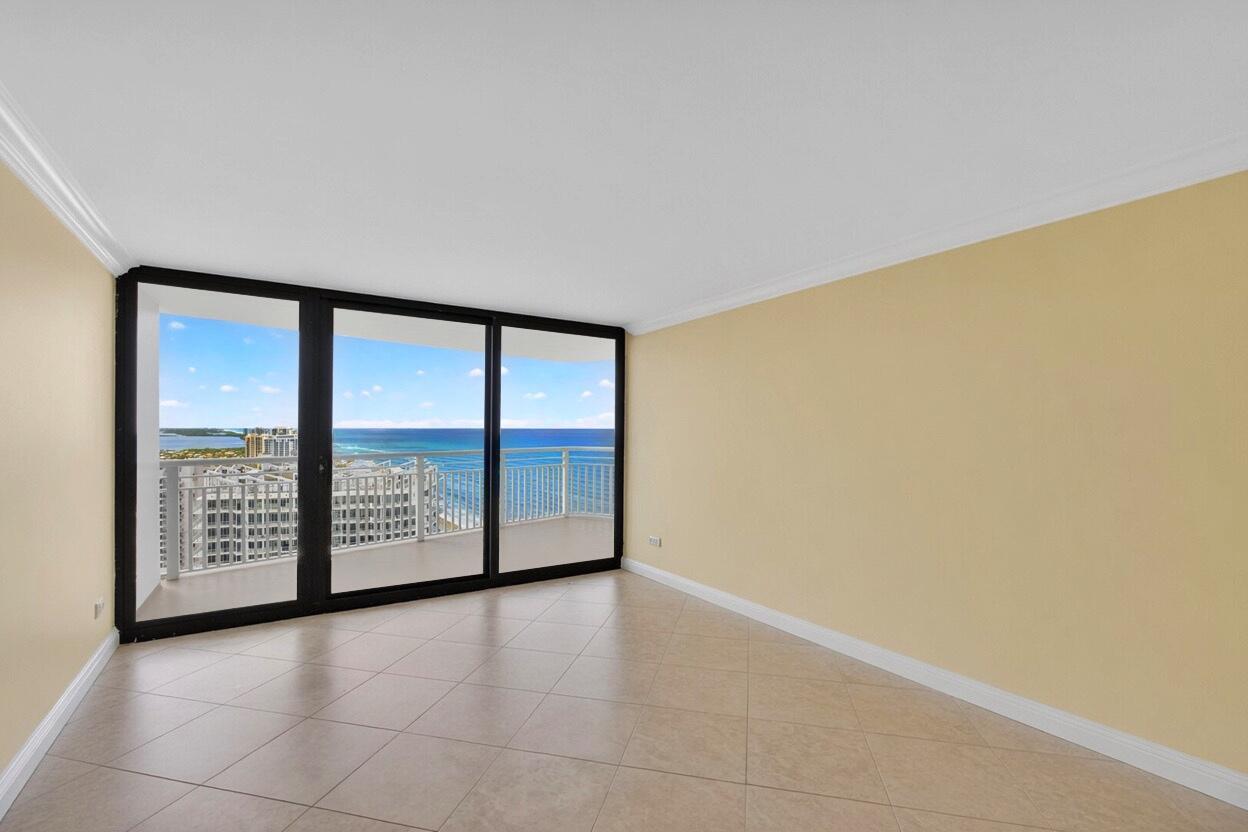 An empty room with beige walls, tile flooring, and a large sliding glass door balcony — 3000 N Ocean Drive # B, Singer Island FL 33404, SINGER ISLAND, FL