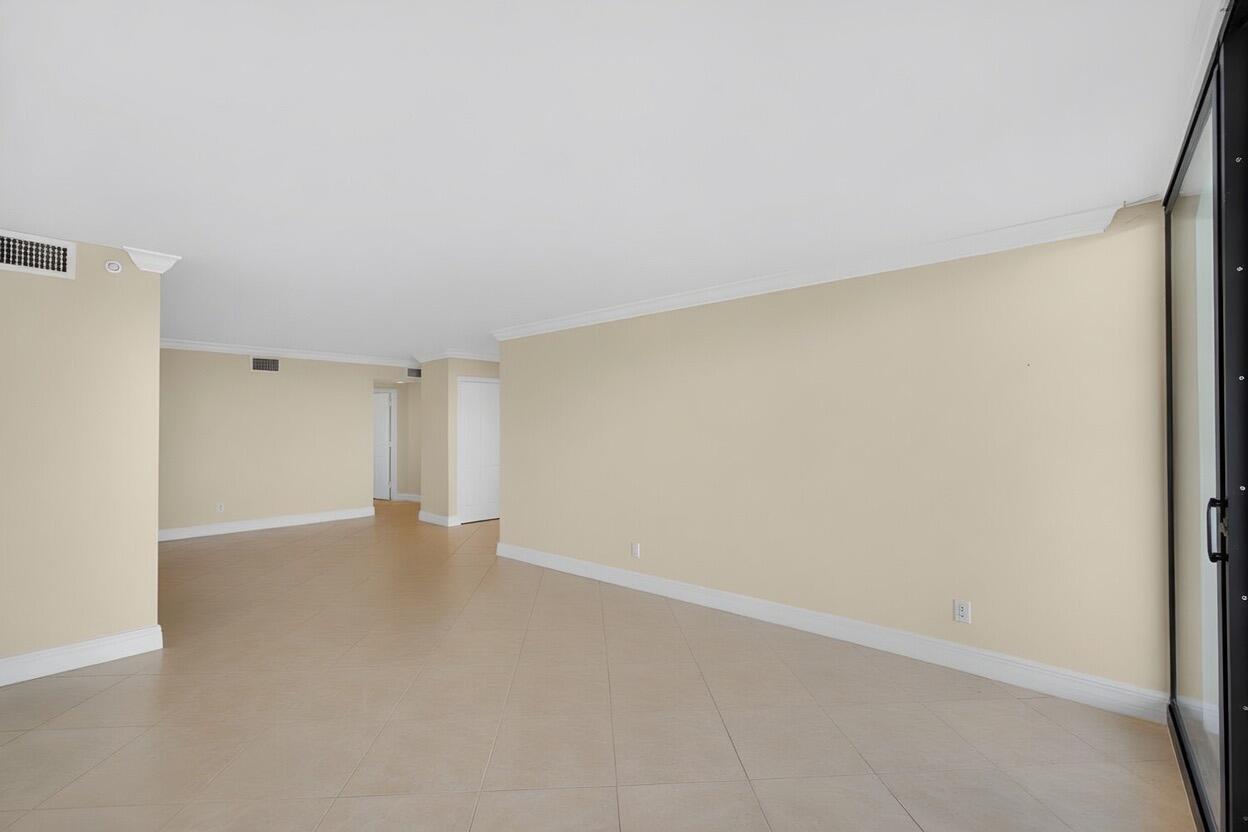 An empty room with beige walls, tile flooring, and a sliding glass door — 3000 N Ocean Drive # B, Singer Island FL 33404, SINGER ISLAND, FL