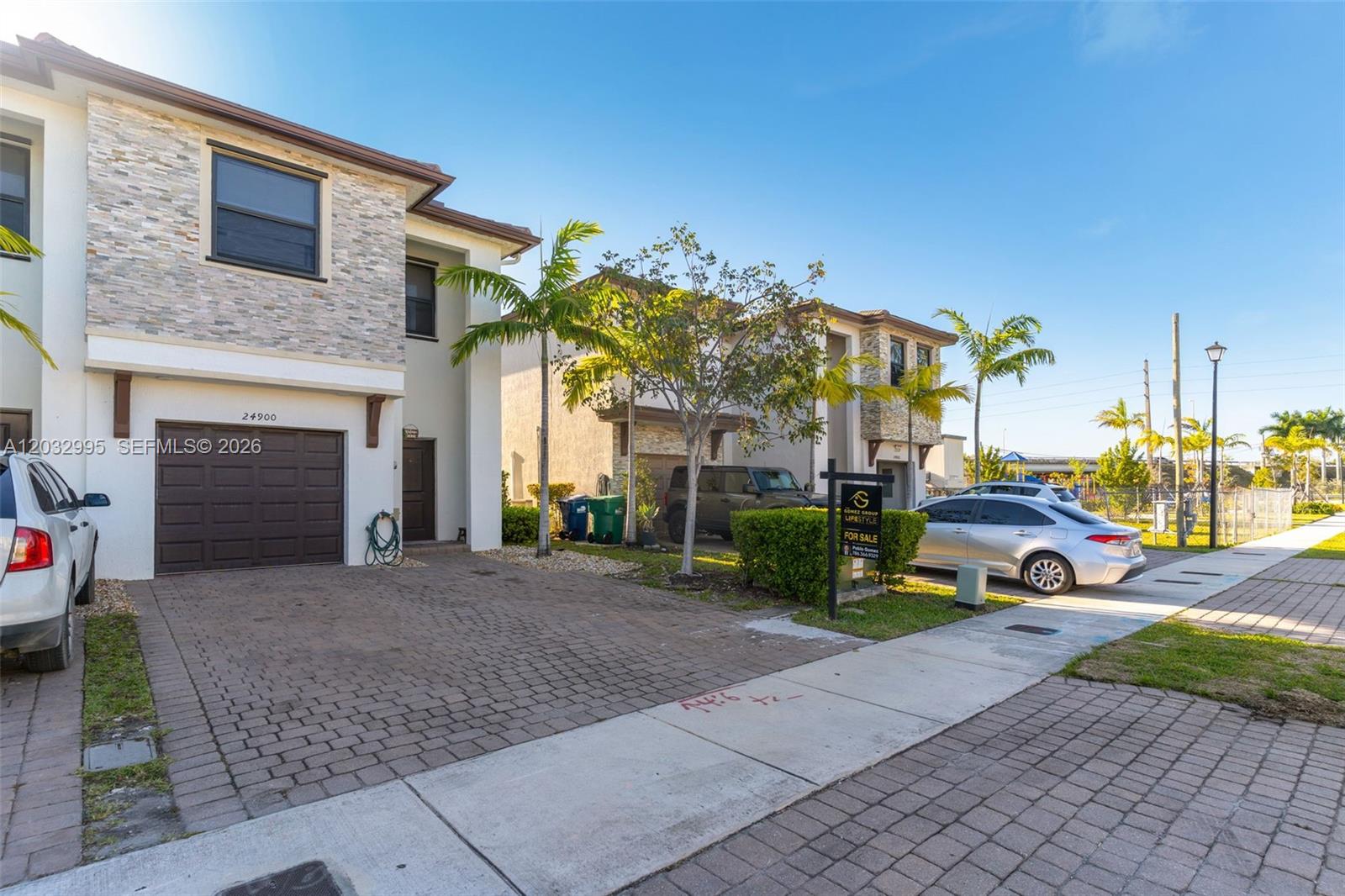 A two-story residential building with a stone facade, a garage, and a paved driveway — 24900 SW 107th Ct, Homestead FL 33032, HOMESTEAD, FL