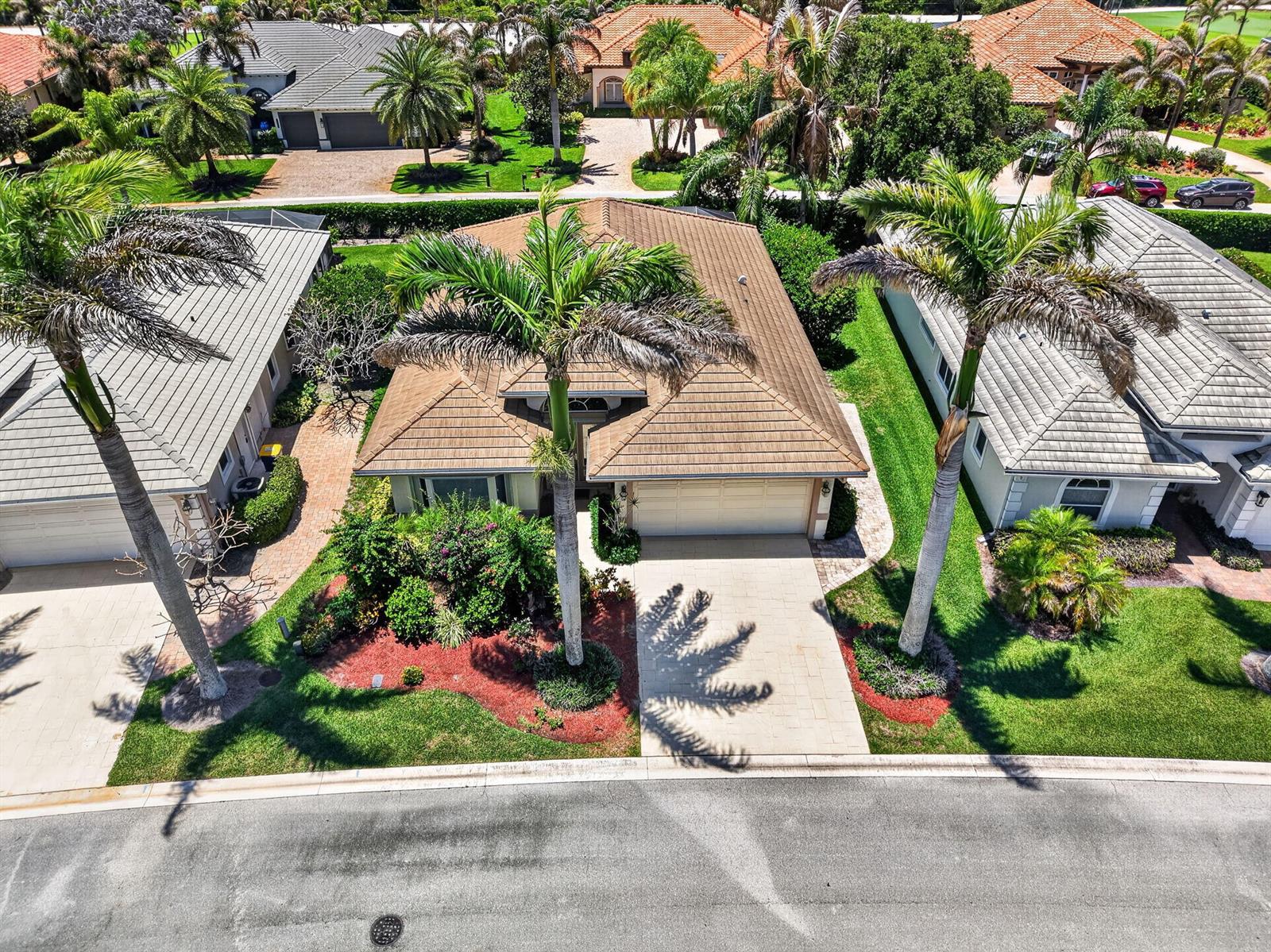 An aerial view shows a tan house with a tiled roof, palm trees, and driveway — 7982 SE Hempstead Circle, Hobe Sound FL 33455, HOBE SOUND, FL