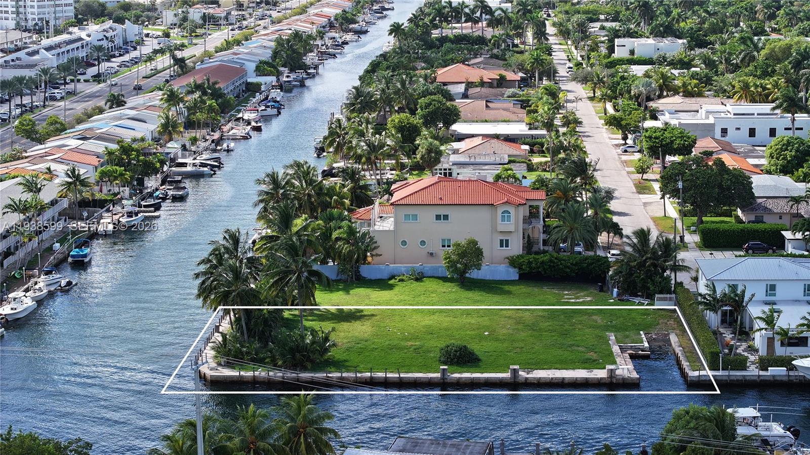 An aerial view shows a vacant waterfront lot with a concrete seawall and dock — 2210 NE 124th St, North Miami FL 33181, NORTH MIAMI, FL