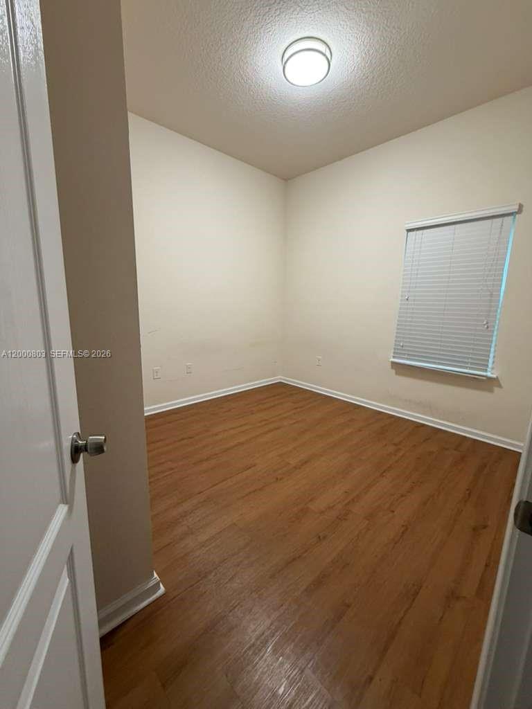 An empty bedroom features light-colored walls, wood-look flooring, and a window with blinds — 2105 Golden Lake Loop St, St Augustine FL 32084, ST AUGUSTINE, FL