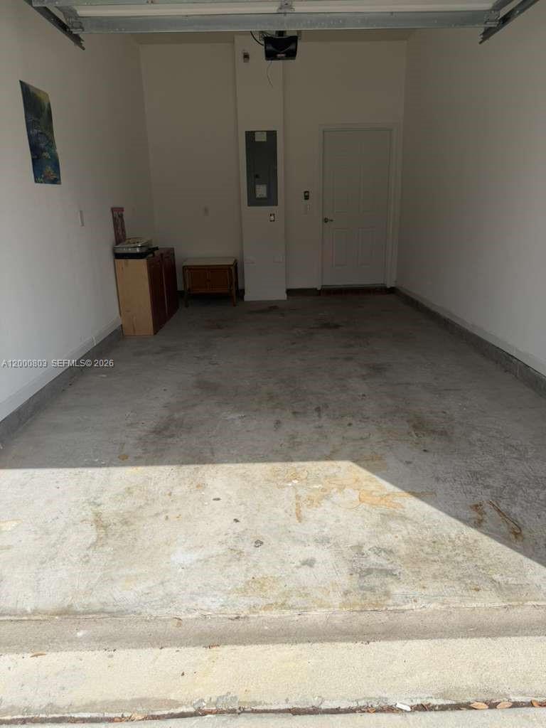 A garage with a concrete floor, a white door, and an electrical panel on the wall — 2105 Golden Lake Loop St, St Augustine FL 32084, ST AUGUSTINE, FL