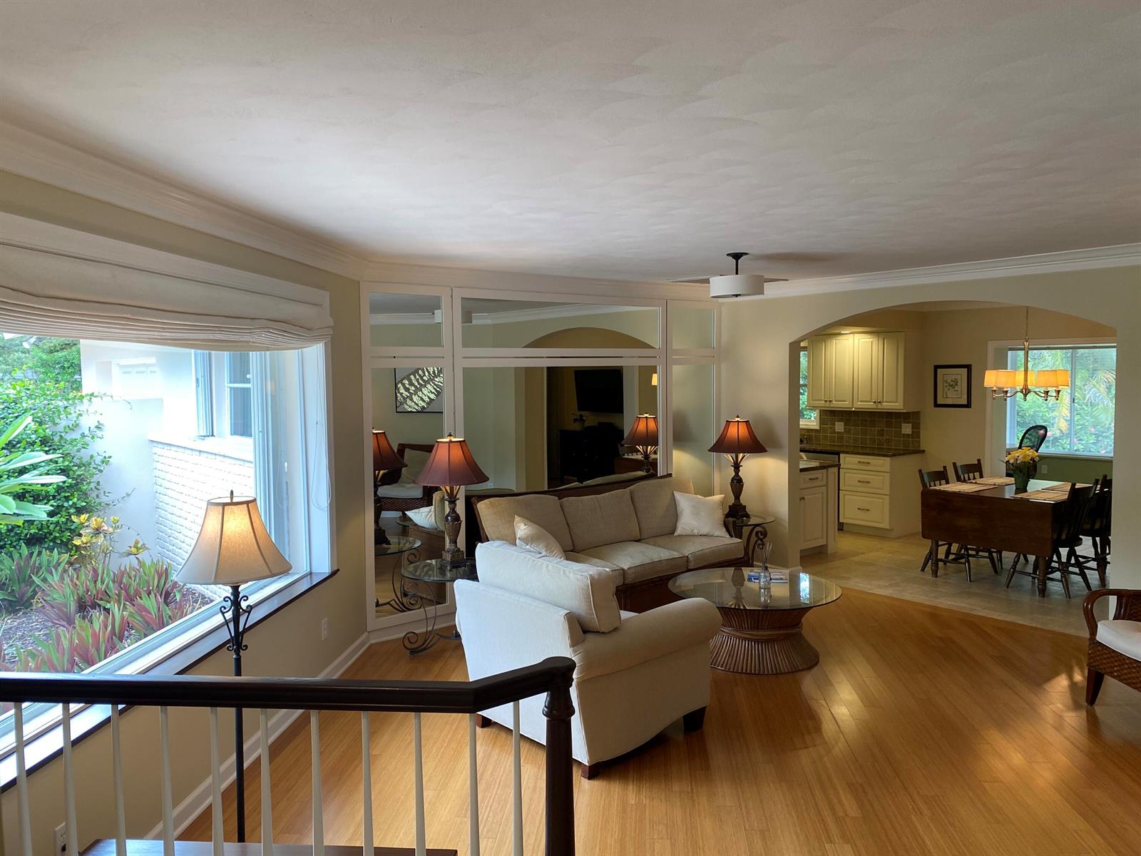 A living room with hardwood floors, a sofa, and an adjacent dining area and kitchen — 535 Flamevine Lane, Vero Beach FL 32963, VERO BEACH, FL