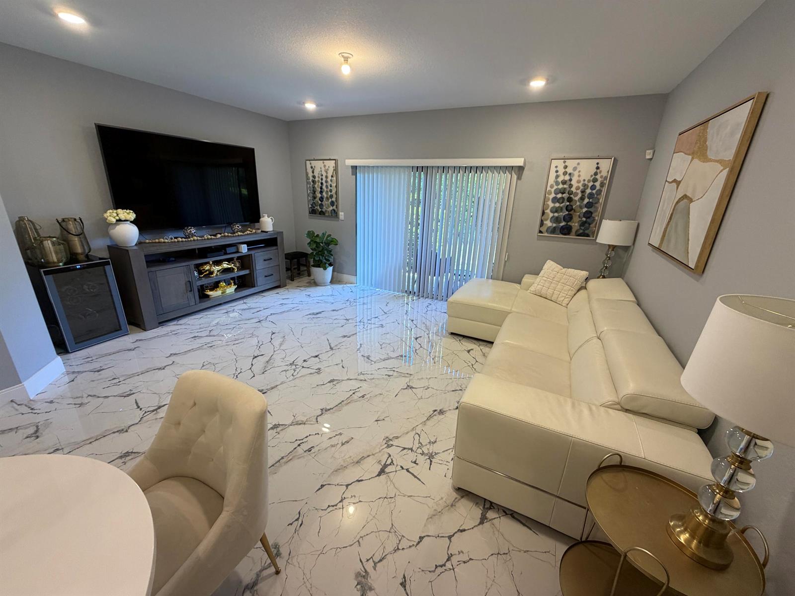 A living room features white marble flooring, a large sectional sofa, and a television console — 178 SE 5th Court SE, Deerfield Beach FL 33441, DEERFIELD BEACH, FL