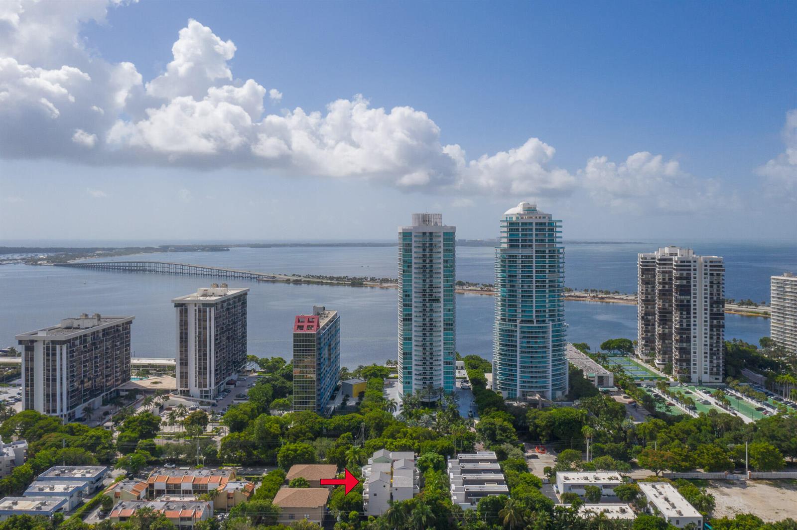 An aerial view shows a residential building marked with a red arrow among high-rises — 2100 Brickell Avenue # 404, Miami FL 33129, MIAMI, FL
