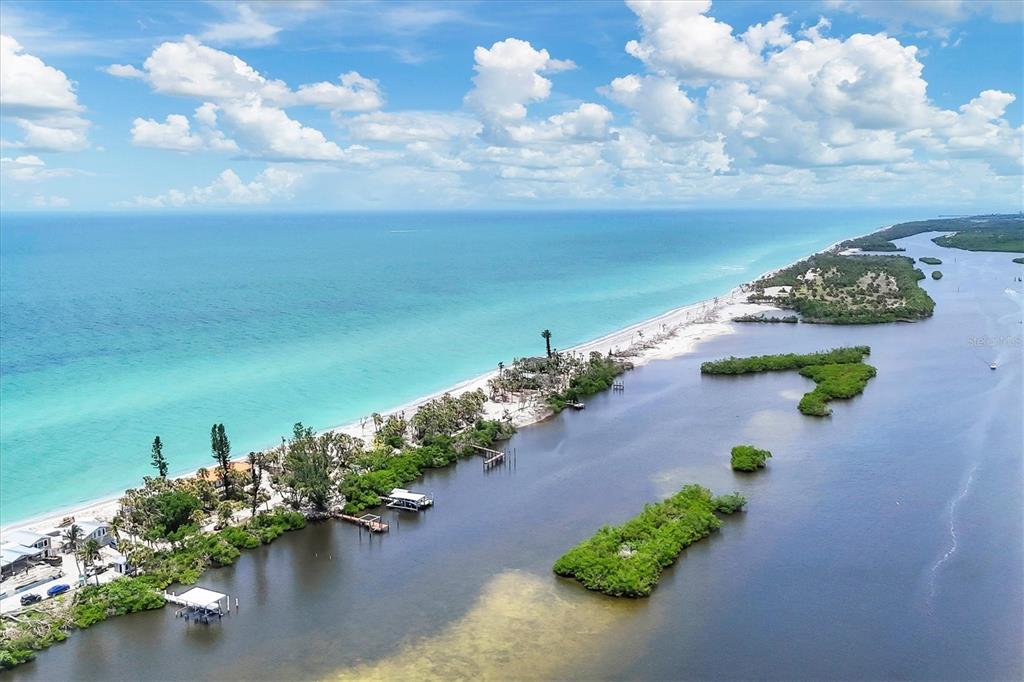 An aerial view shows a narrow beach strip separating the ocean from a calm bay — 804 N MANASOTA KEY ROAD, ENGLEWOOD, FL