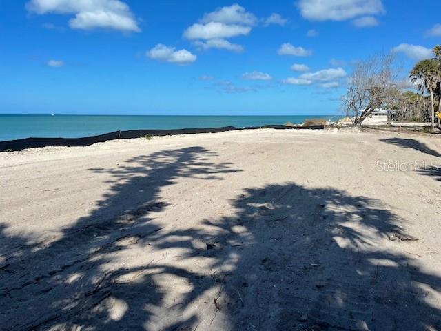 A vacant, sandy waterfront lot features a black silt fence along the shoreline — 804 N MANASOTA KEY ROAD, ENGLEWOOD, FL