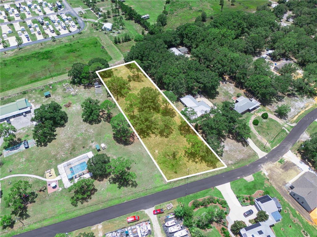 An aerial view shows a rectangular vacant lot outlined in white amidst a residential area — 735 KEEN ROAD, FROSTPROOF, FL
