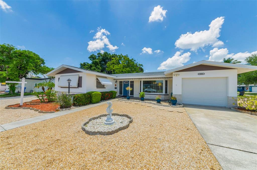 A single-story house with a white exterior, a gravel front yard, and a one-car garage — 5992 32ND AVENUE N, ST PETERSBURG, FL