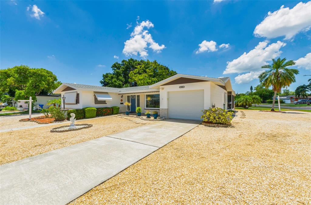 A single-story house with a white exterior, a garage, and a gravel front yard — 5992 32ND AVENUE N, ST PETERSBURG, FL
