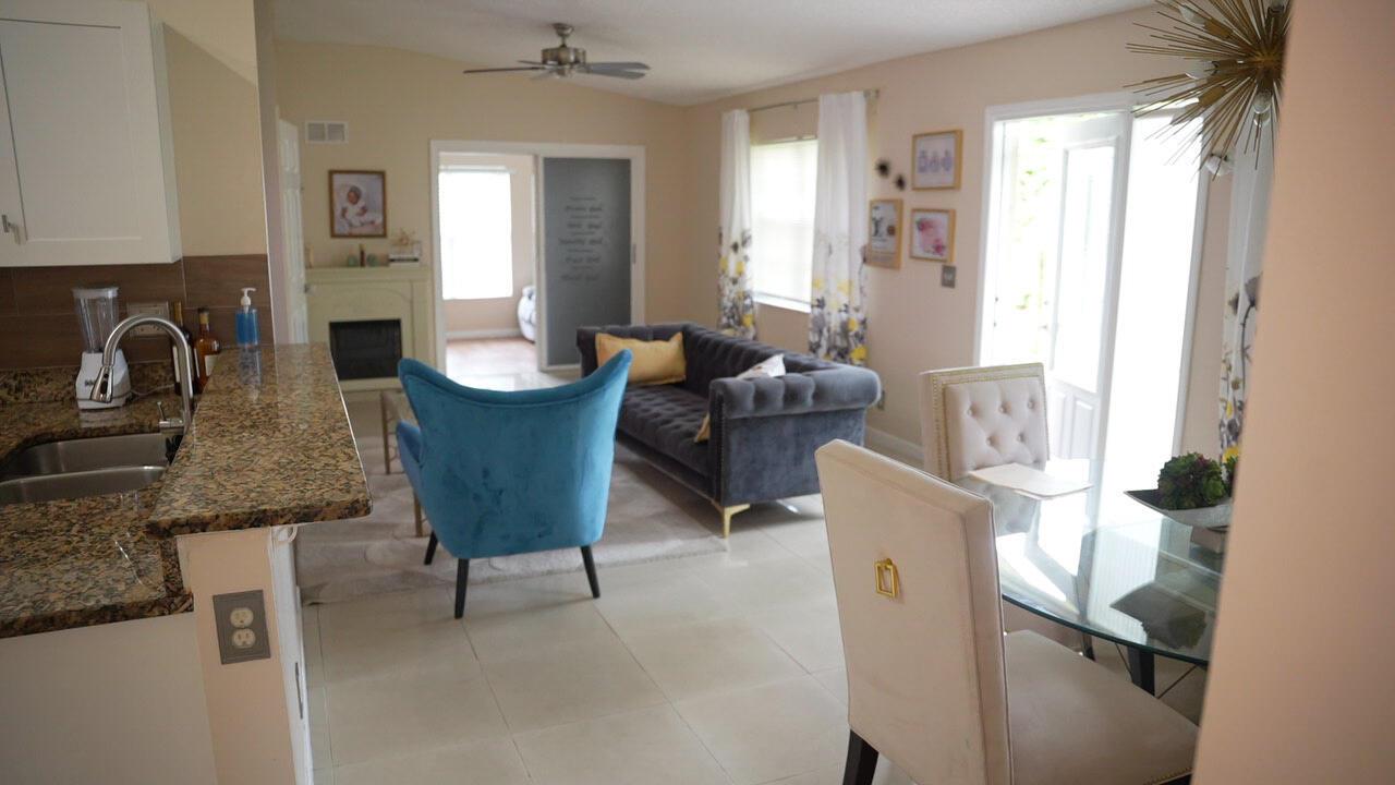 A view from a kitchen counter looking into a living room and dining area — 201 Maplewood Drive # 201, FL 33415, FL