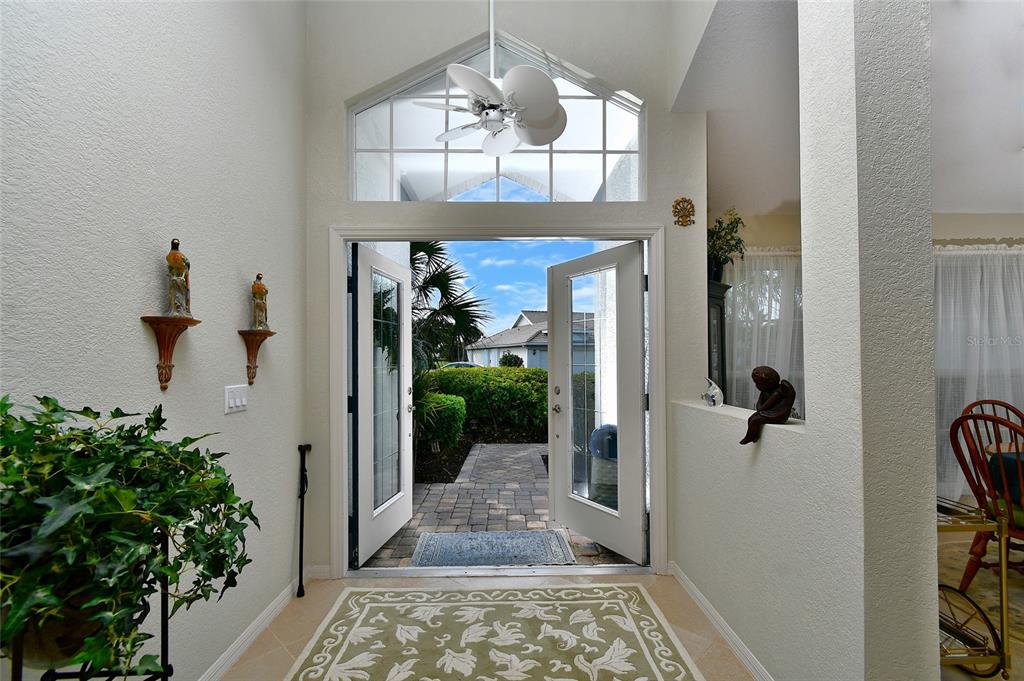 An entryway features double glass doors, a ceiling fan, and a patterned area rug — 24050 REDFISH COVE DRIVE, PUNTA GORDA, FL