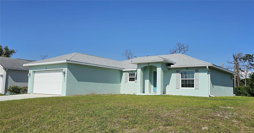 A light green single-story house with a two-car garage and a covered front entryway — 7436 MICHAEL STREET, ENGLEWOOD, FL