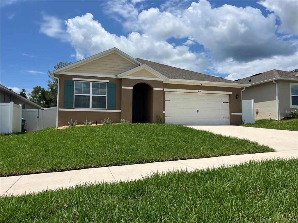 A single-story house with a brown exterior, beige gable, and a two-car garage — 3031 STATEN DRIVE, DELTONA, FL