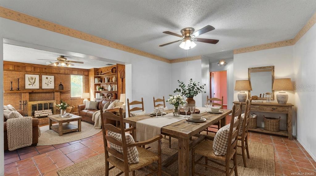 A living room with tiled floors, a brick fireplace, and wood-paneled walls — 4104 E COUNTY ROAD 540A, LAKELAND, FL