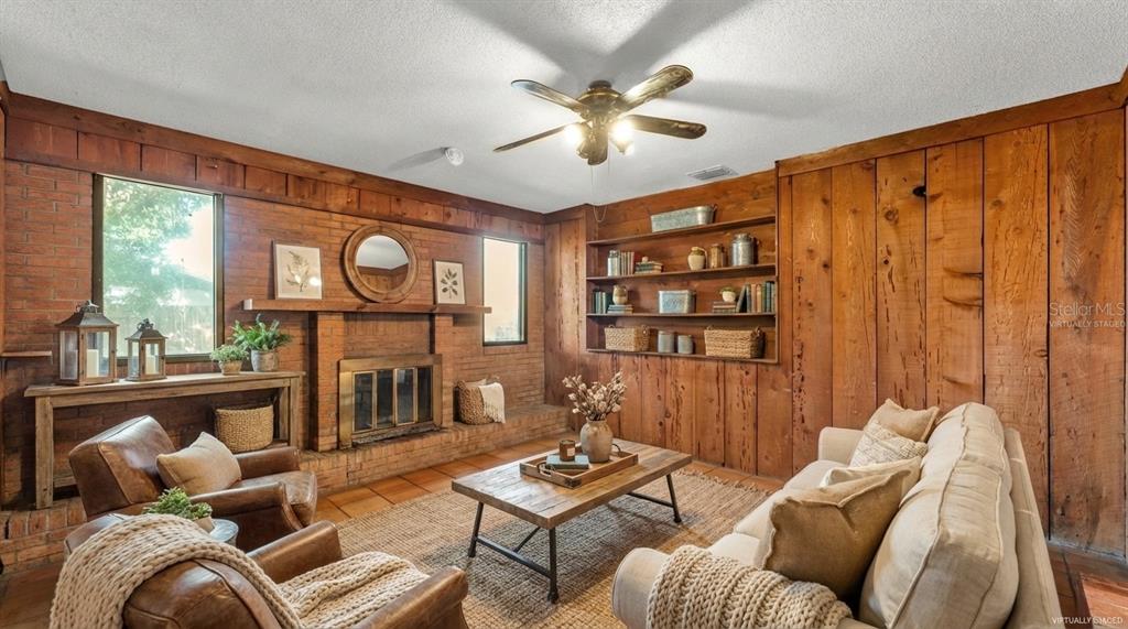 A dining area with a wooden table and chairs flows into a living room with brick — 4104 E COUNTY ROAD 540A, LAKELAND, FL