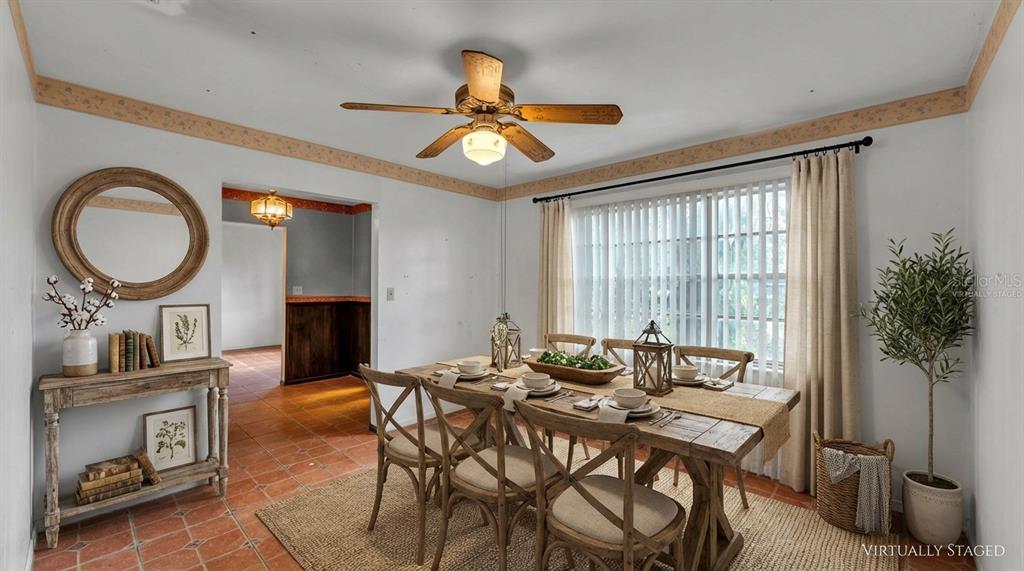 A living room features a brick fireplace, wood-paneled walls, built-in shelves, and terracotta tile flooring — 4104 E COUNTY ROAD 540A, LAKELAND, FL