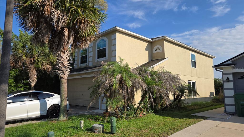 A two-story beige house with a garage and palm trees in the front yard — 15108 HARROWGATE WAY, WINTER GARDEN, FL