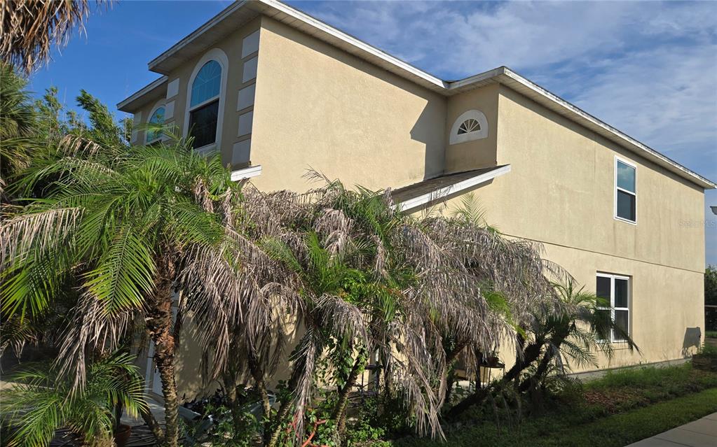 A two-story beige stucco house exterior features a palm tree in the front yard — 15108 HARROWGATE WAY, WINTER GARDEN, FL