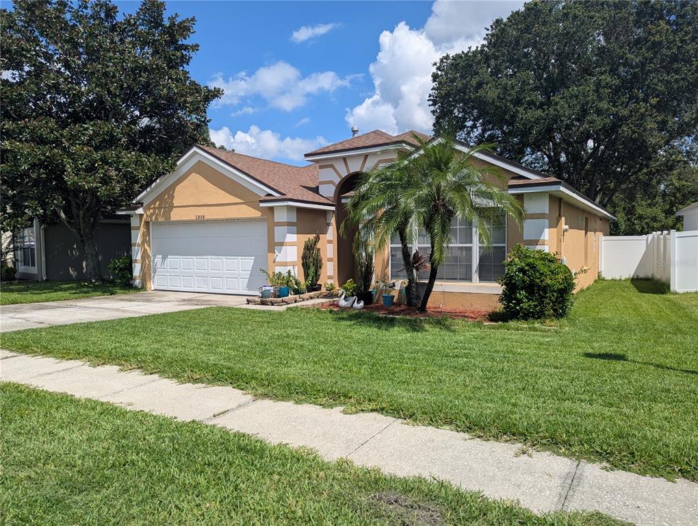 A single-story house with a tan stucco exterior, white trim, and a two-car garage — 2908 EGRETS LANDING, LAKE MARY, FL