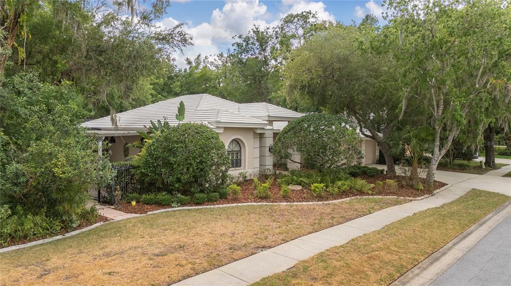 A single-story house with a white tile roof sits behind a landscaped yard and sidewalk — 50 KELLEYS TRAIL, OLDSMAR, FL