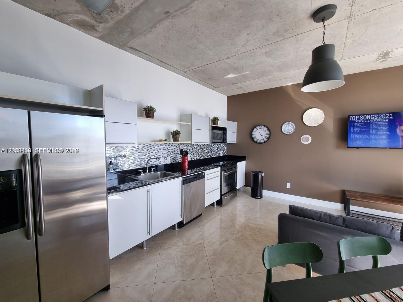A modern kitchen features white cabinets, stainless steel appliances, and a concrete ceiling — 690 SW 1st Ct # 1827, Miami FL 33130, MIAMI, FL
