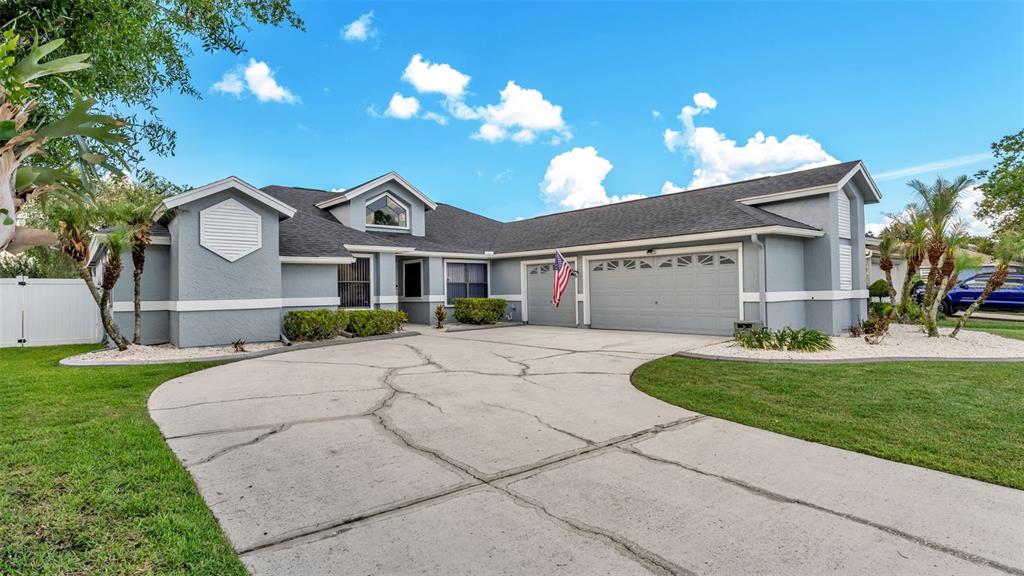 A single-story house with a gray exterior, a cracked concrete driveway, and a two-car garage — 2331 PEPPERCORN STREET, KISSIMMEE, FL