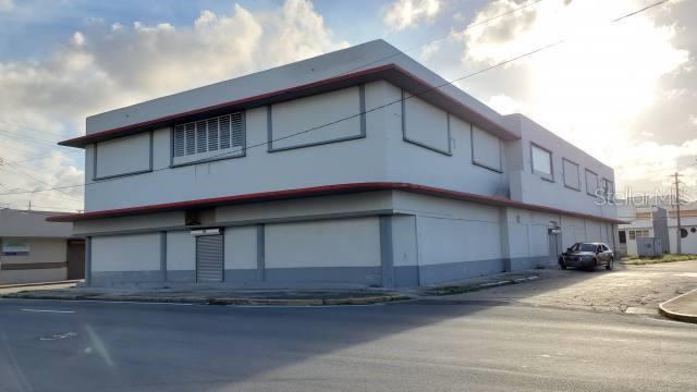 A two-story commercial building with a light-colored exterior and a small parking area — PR 2 INT DELICIAS ST, ARECIBO, PR