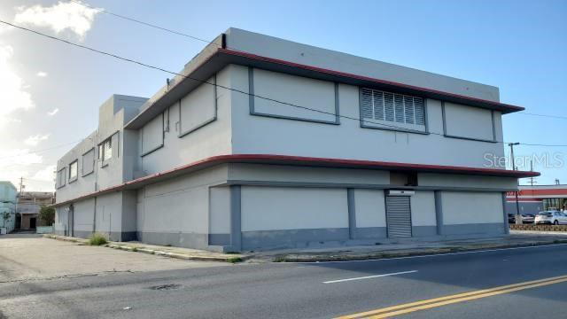 A two-story commercial building with light gray walls and a red trim accent — PR 2 INT DELICIAS ST, ARECIBO, PR