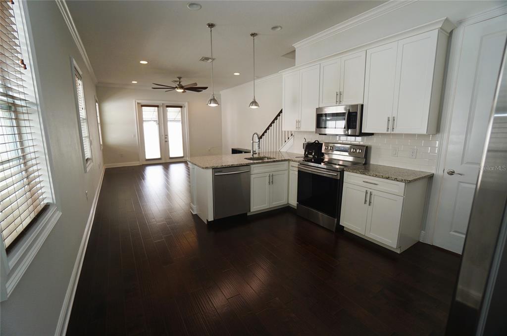 A kitchen with white cabinets, stainless steel appliances, and dark wood floors — 4250 W CARMEN STREET, TAMPA, FL