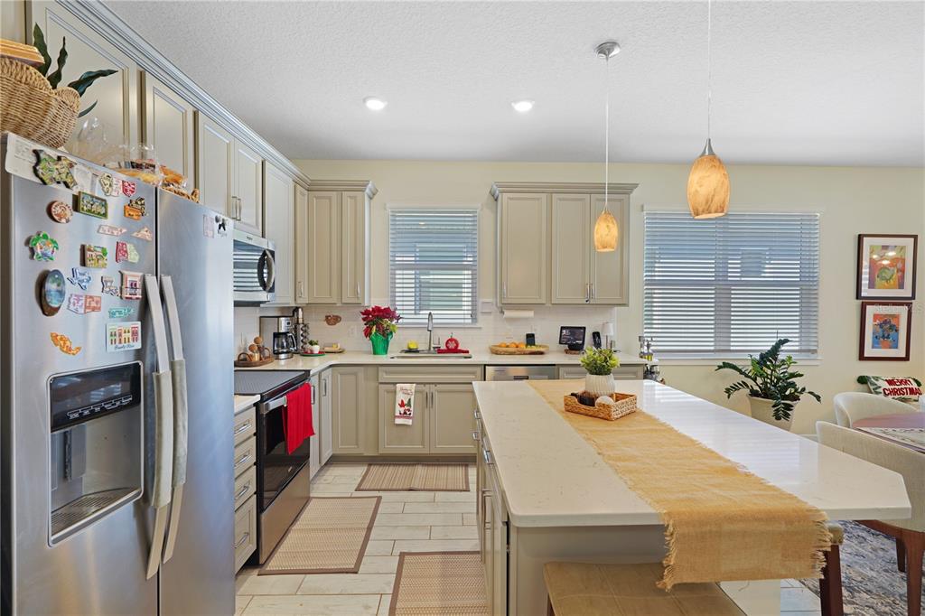 A kitchen with light-colored cabinets, a large central island, and stainless steel appliances — 1881 SPRING SHOWER CIRCLE, KISSIMMEE, FL
